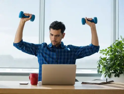 Man using dumbbells while working in office