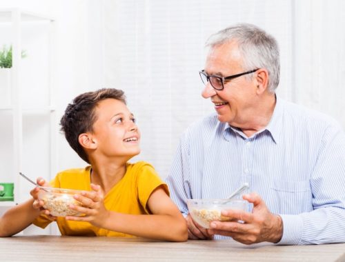 Grandfather and grandson eating oatmeal