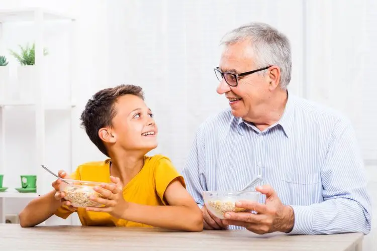 Grandfather and grandson eating oatmeal