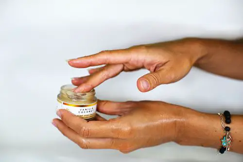 Two hands holding a pot of CBD cream