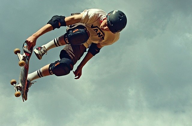 A skateboarder wearing helmet, knee pads, and elbow pads