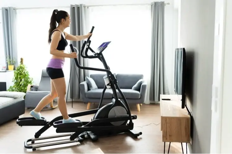 Woman using an elliptical machine at home